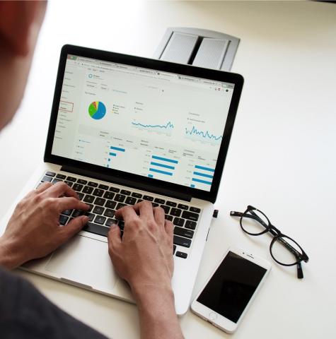 closeup of a laptop displaying data and graphs